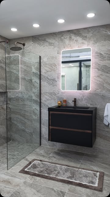 Grey marble bathroom with a black vanity unit